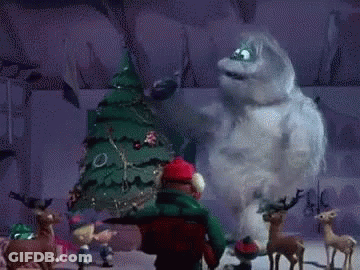 A Cartoon Character Is Standing In Front Of A Christmas Tree And Reindeer . GIF