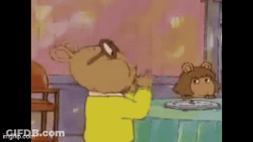 A Cartoon Character Is Standing In Front Of A Table With A Plate Of Food On It . GIF