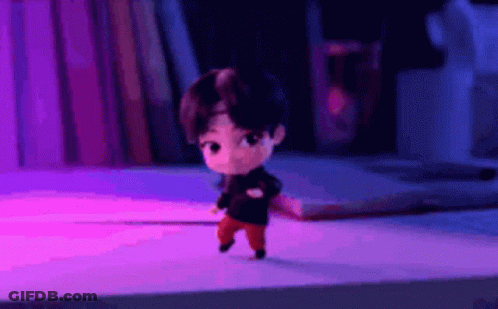 A Cartoon Character Is Standing On A Desk In Front Of A Bookshelf . GIF