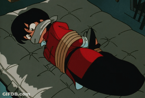 A Cartoon Character Is Tied Up On A Bed And Has A Bandage On His Face GIF