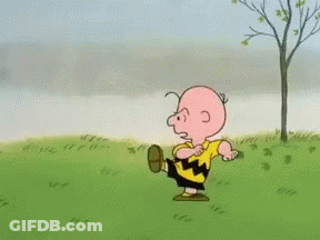 A Cartoon Character Named Charlie Brown Is Running On A Grassy Field GIF