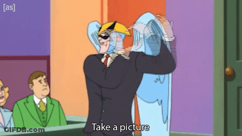 A Cartoon Character Says Take A Picture While Holding A Ghost GIF
