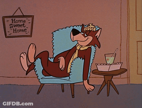 A Cartoon Character Sits In A Chair With A Sign That Says Home Sweet Home GIF