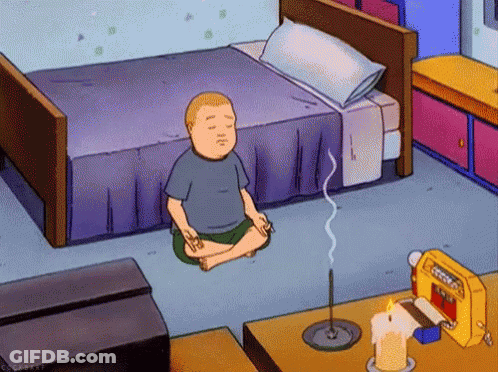 A Cartoon Character Sits In A Lotus Position In Front Of A Bed GIF