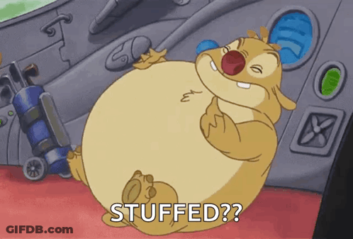 A Cartoon Character With A Big Belly Is Sitting On A Red Carpet And Says Stuffed ? GIF