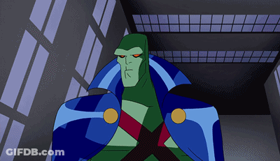 A Cartoon Character With A Blue Cape And Red Eyes Stands In Front Of A Building GIF