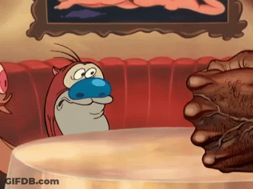 A Cartoon Character With A Blue Nose Is Sitting At A Table With A Fist . GIF