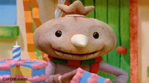 A Cartoon Character With A Crown On His Head Is Holding A Cake GIF