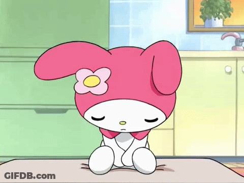 A Cartoon Character With A Flower On Her Head Is Sitting On A Table With Her Eyes Closed . GIF