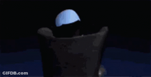 A Cartoon Character With A Large Head Is Sitting In A Chair With His Hands Folded . GIF