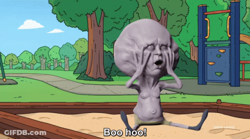 A Cartoon Character With A Large Head Is Sitting In A Sandbox And Says Boo Hoo GIF