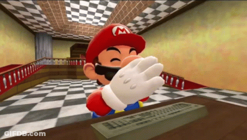 A Cartoon Character With A M On His Hat Is Sitting At A Table With A Remote Control . GIF