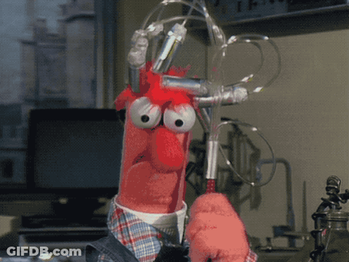 A Cartoon Character With Big Eyes Is Holding A Pair Of Scissors In A Laboratory GIF