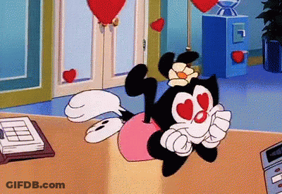 A Cartoon Character With Hearts In Her Eyes Is Laying On A Table GIF