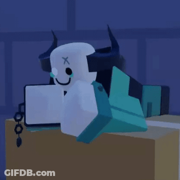 Horned Cartoon Character Laying On Table With Laptop GIF
