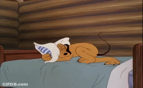 A Cartoon Dog Is Sleeping On A Bed With A Pillow In Its Mouth . GIF