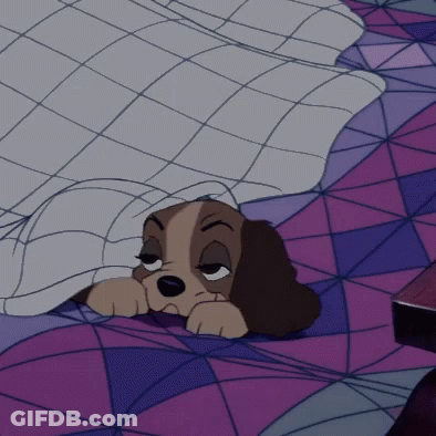 A Cartoon Dog Is Sleeping Under A Blanket On A Bed GIF