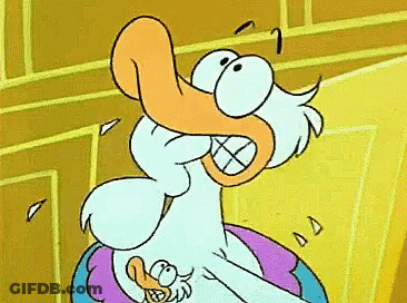 A Cartoon Duck With An Orange Beak Is Sitting On A Pillow GIF
