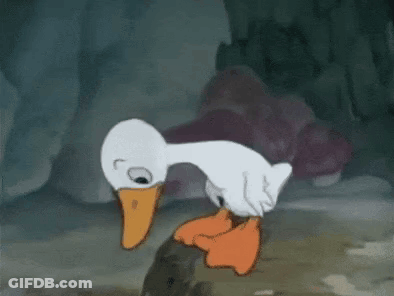 A Cartoon Duck With An Orange Beak Is Standing Next To A Rock . GIF