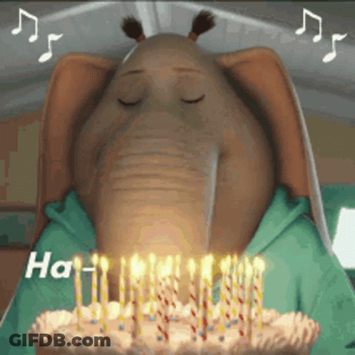 A Cartoon Elephant Blowing Out Candles On A Cake GIF