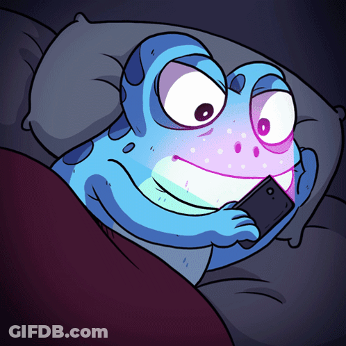 A Cartoon Frog Is Laying In Bed Looking At His Phone GIF