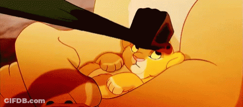 A Cartoon Lion Is Laying On A Couch With A Black Object On Its Head GIF