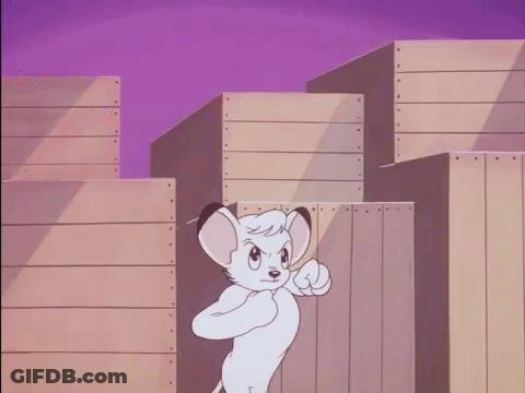 A Cartoon Lion Is Standing In Front Of A Wooden Fence And Pointing At The Camera . GIF