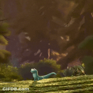 A Cartoon Lizard Is Sitting On A Grassy Hill And Smiling GIF