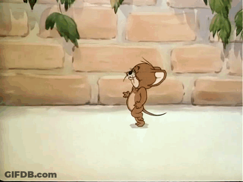 A Cartoon Mouse Is Standing In Front Of A Brick Wall With Leaves Hanging From It GIF