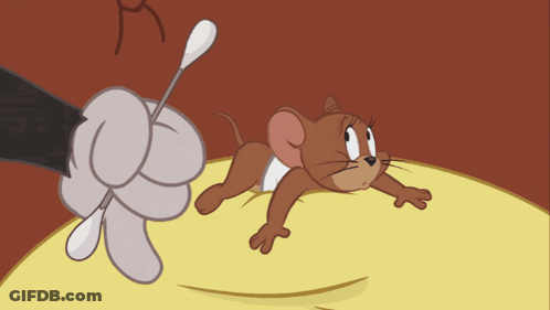 A Cartoon Mouse Laying On A Yellow Surface With A Hand Holding A Stick GIF