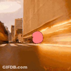 A Cartoon Of A Bubble Gum Character Is Driving Down A Street GIF