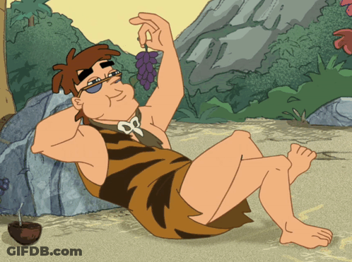 A Cartoon Of A Caveman Sitting On The Ground Holding A Grape GIF