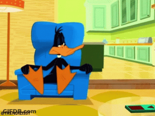 A Cartoon Of A Duck Sitting In A Chair GIF