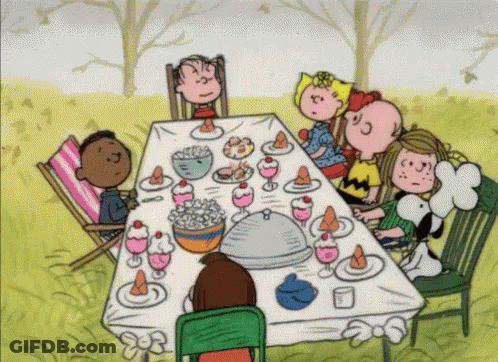 A Cartoon Of A Group Of Children Sitting Around A Table With Food On It GIF