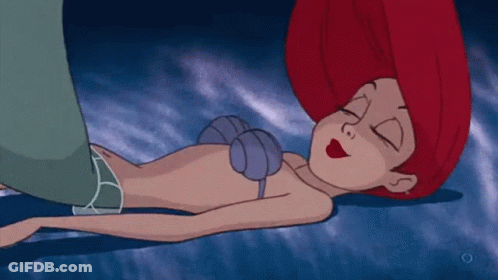 A Cartoon Of A Little Mermaid Sleeping On The Ground GIF
