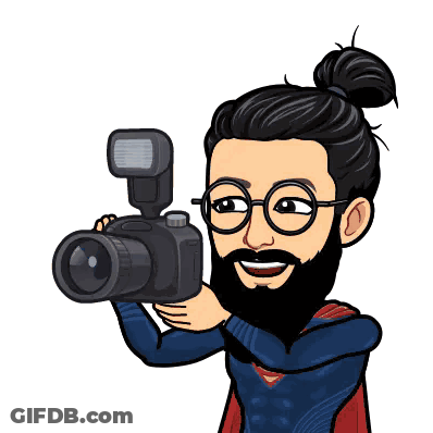 A Cartoon Of A Man Holding A Camera With A Flash GIF