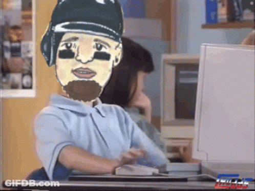 A Cartoon Of A Man With A Beard Is Sitting At A Desk GIF