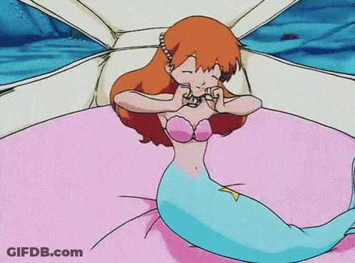 A Cartoon Of A Mermaid Laying On A Bed With Her Eyes Closed GIF