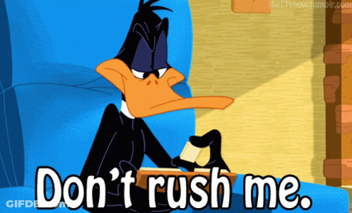 A Cartoon Of Daffy Duck Sitting On A Couch With The Words " Don 'T Rush Me " Below Him GIF