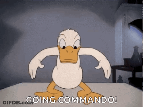 A Cartoon Of Donald Duck Standing On A Table With The Words `` Going Commando '' Written Below Him . GIF