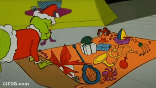 A Cartoon Of Grinch Laying On A Rug With Toys On It GIF