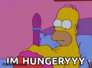 A Cartoon Of Homer Simpson Laying In A Bed With The Words Im Hungryyy Written Below Him GIF