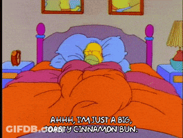 A Cartoon Of Homer Simpson Laying In Bed Saying Ahhh I 'M Just A Big Toasty Cinnamon Bun. GIF