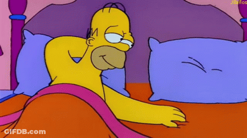 A Cartoon Of Homer Simpson Laying In Bed With A Purple Pillow GIF