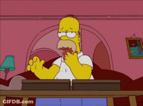 A Cartoon Of Homer Simpson Sitting At A Desk GIF