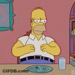 A Cartoon Of Homer Simpson Sitting At A Table GIF