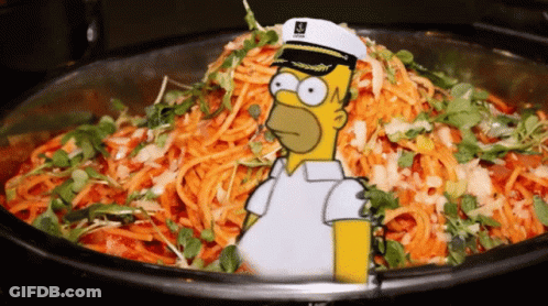 A Cartoon Of Homer Simpson Wearing A Captain 'S Hat Stands In Front Of A Bowl Of Carrots GIF
