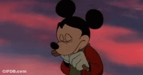 A Cartoon Of Mickey Mouse Holding A Stick With The Words Otan Den Benei O Nek Below Him GIF