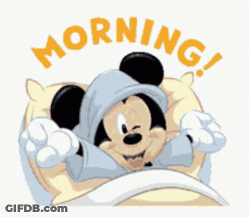 A Cartoon Of Mickey Mouse Laying In Bed With The Word Morning Written Above Him GIF