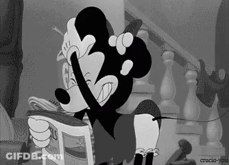 A Cartoon Of Mickey Mouse Reading A Newspaper GIF